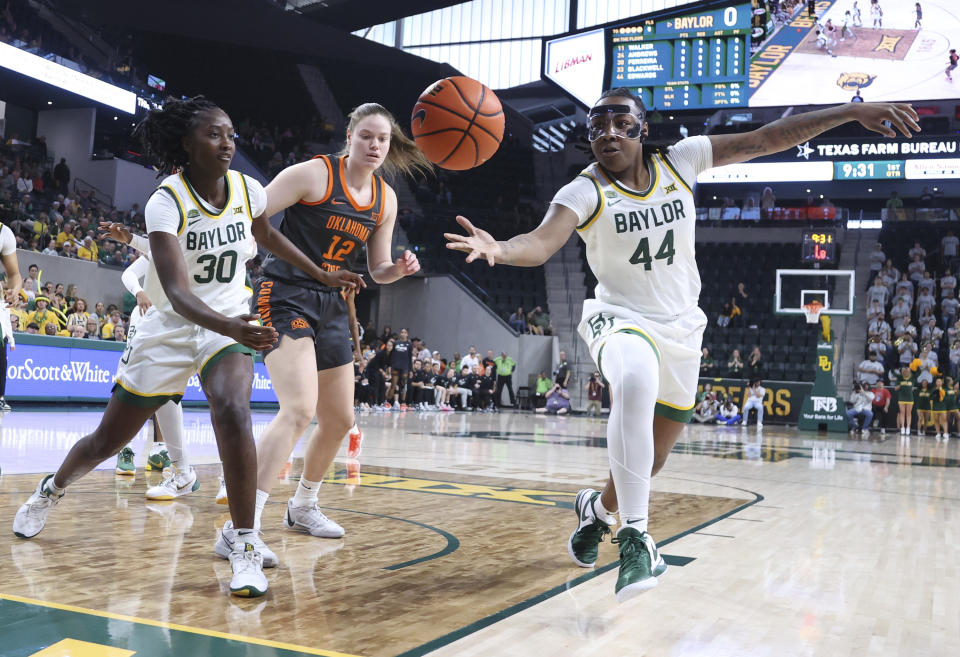 Baylor forward Dre'Una Edwards, right, reaches for a loose ball over Oklahoma State forward Lior Garzon and teammate guard Catarina Ferreira, left, in the first half of an NCAA college basketball game, Sunday, March 3, 2024, in Waco, Texas. (Rod Aydelotte/Waco Tribune-Herald via AP)