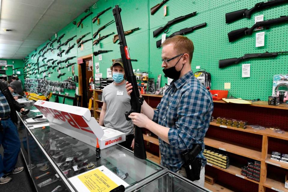 Hyatt Gun Shop salesmen Ted Shore, right, and Ian Mahathey assemble a shotgun for a customer on Wednesday, January 20, 2021. The store is seeing unprecedented demand for guns and ammunition, owner Larry Hyatt said.