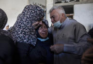 Palestinian relatives mourn over the bodies of four brothers from the Tanani family that werer found under the rubble of a destroyed house following Israeli airstrikes in Beit Lahiya, northern Gaza Strip, Friday, May 14, 2021. (AP Photo/Khalil Hamra)