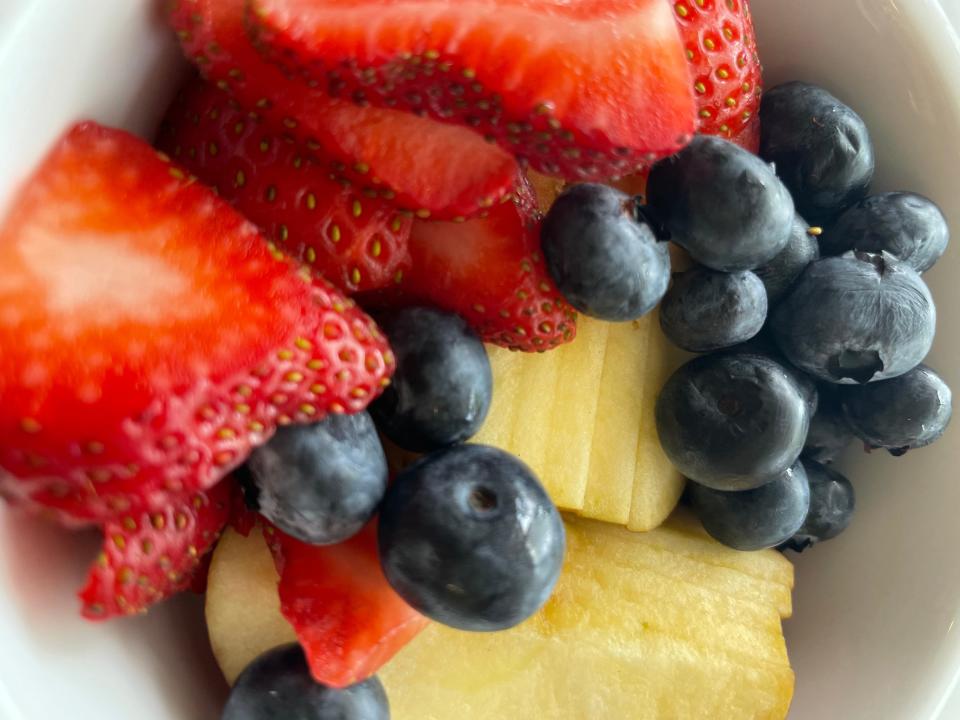 A bowl of strawberries, pineapple, and blueberries