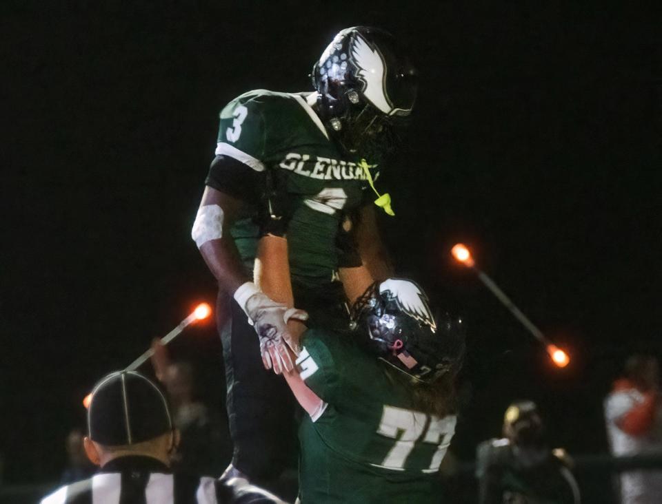 GlenOak’s Jamar Johnson is held up by Anthony French after scoring a touchdown to give GlenOak a 10-7 lead over Lorain in the fourth quarter, Friday, Oct. 27, 2023.