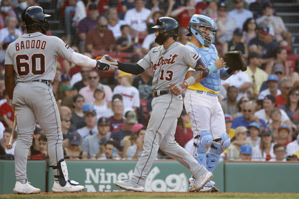 Detroit Tigers' Eric Haase (13) celebrates with teammate Akil Baddoo (60) after hitting a home run as Boston Red Sox catcher Reese McGuire, right, looks on during the fifth inning of a baseball game at Fenway Park, Saturday, Aug. 12, 2023, in Boston. (AP Photo/Mary Schwalm)