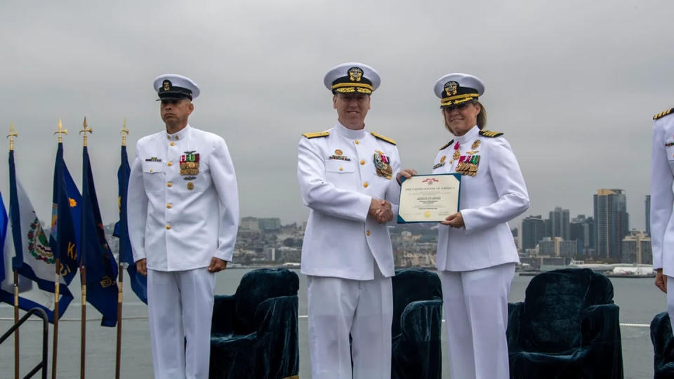 Rear Adm. Kevin Lenox, commander, Carrier Strike Group 3, presents a Legion of Merit to Capt. Amy N. Bauernschmidt, during a change of command ceremony in May. (MC2 Madison Cassidy/U.S. Navy)