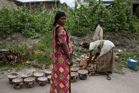 A Bahavu woman stands (L) as Pygmy women sell pottery in the Bahavu village of Bugarula on Idjwi island in the Democratic Republic of Congo, November 23, 2016. REUTERS/Therese Di Campo