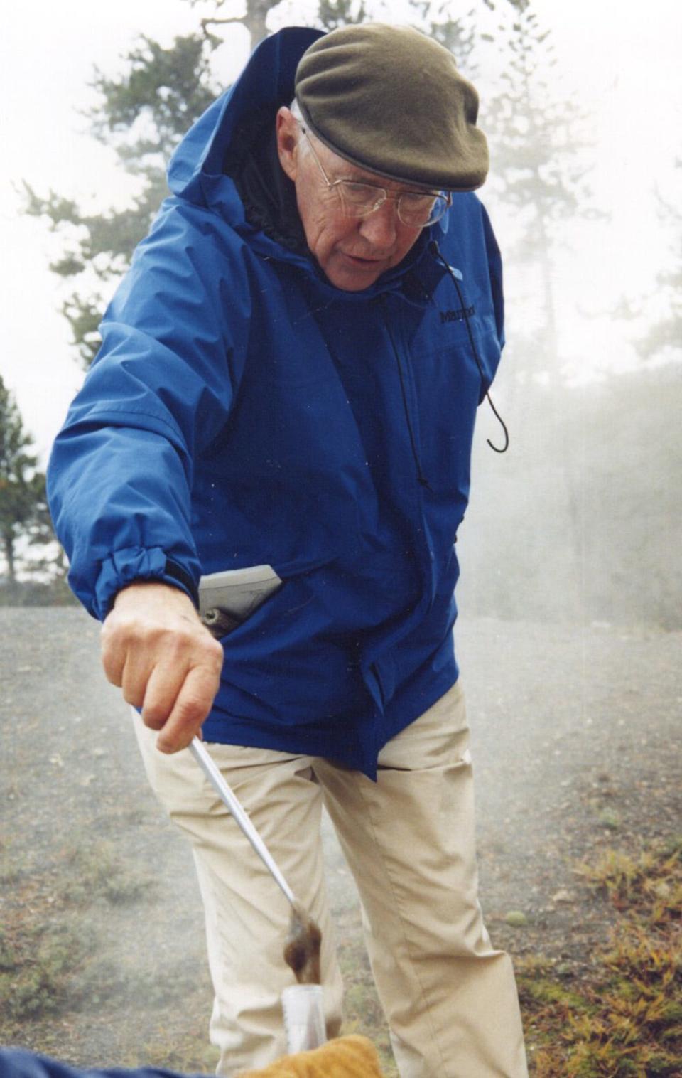 Tom Brock collects a sample from a hot spring in Yellowstone National Park in 1995.  A pioneer in his field, Brock's discovery of bacteria that can live in extremely high temperatures led to major advancements in biology and medicine, including the technology that is used in COVID-19 PCR tests.