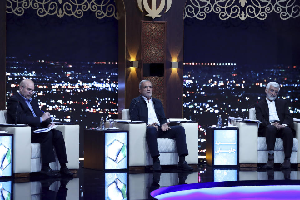 In this picture made available by Iranian state-run TV, IRIB, reformist presidential candidate for June 28 election Masoud Pezeshkian, center, who is a parliament member, speaks in a debate of the candidates as Mohammad Bagher Qalibaf, left, and Saeed Jalili listen at the TV studio in Tehran, Iran, Monday, June 17, 2024. (Morteza Fakhri Nezhad/IRIB via AP)
