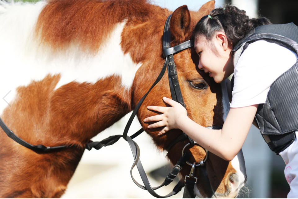 比起在醫院做復健，在馬場騎馬做馬術治療，和馬兒互動，孩子的喜悅全寫在臉上。（張兆遠提供）