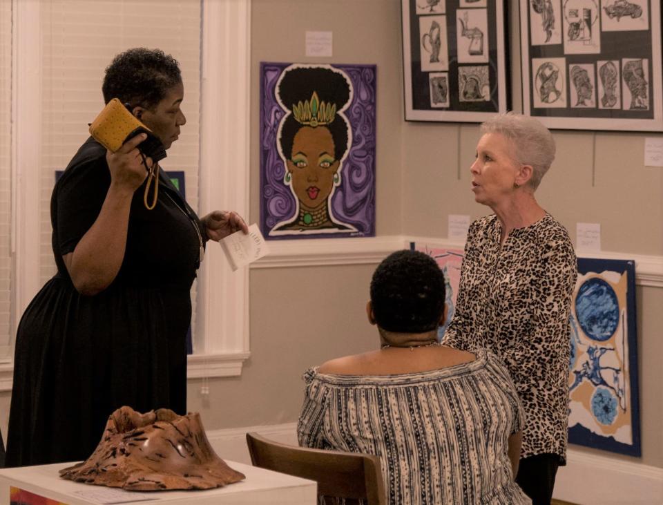 Former Guild President Nan Gunn (at right) discusses work on display at the gallery.