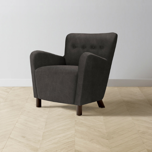 dark grey Maiden Home Perry club chair in room with light wood floors and light gray wall