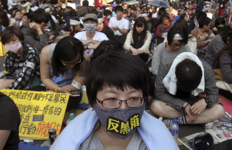 A protester wearing a banner reading "Anti Black Box" joins a rally against a trade pact with China, outside the legislature in Taipei, Taiwan, Sunday, March 23, 2014. Opponents of a trade pact with China have demonstrated in and around Taiwan's legislature since Tuesday, in the most serious challenge to date to President Ma Ying-jeou's policy of moving the democratic island of 23 million people economically closer to Communist China. (AP Photo/Chiang Ying-ying)