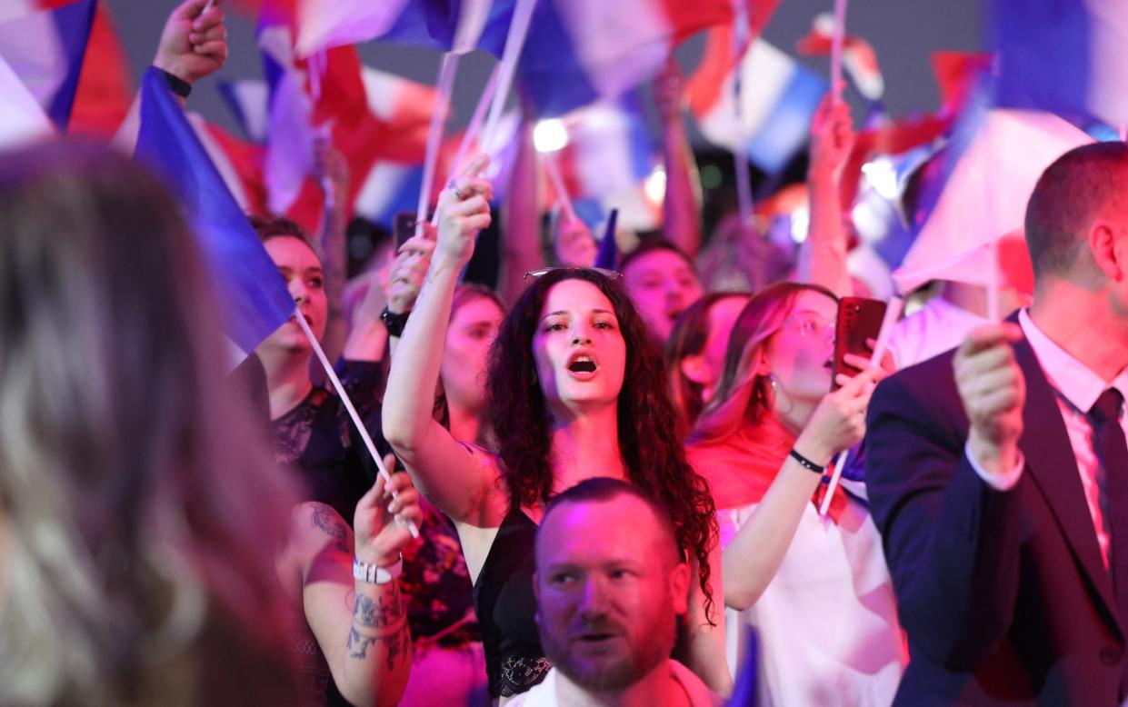 Supporters fly French flags during the results evening organised by the National Rally party