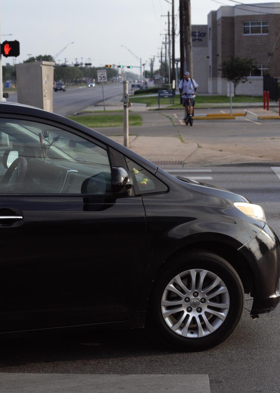 A car turns right onto Ayers Street at the intersection of Baldwin Boulevard.