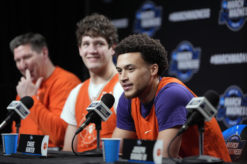 Clemson guard Chase Hunter, right, fields questions as head coach Brad Brownell and center PJ Hall listen, from left, ahead of their Elite Eight college basketball game in the NCAA tournament Friday, March 29, 2024, in Los Angeles. Clemson plays Alabama on Saturday. (AP Photo/Ryan Sun)