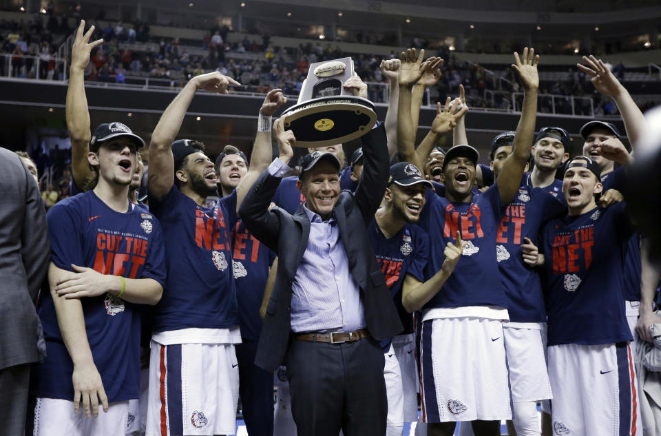 FILE - Gonzaga head coach Mark Few, center, holds a trophy as his players surround him after a win over Xavier in an NCAA Tournament college basketball regional final game Saturday, March 25, 2017, in San Jose, Calif. The players and coaches on USA Basketball’s roster for the World Cup that starts next week are in possession of a combined 16 NBA championship rings. The players and coaches on USA Basketball’s roster for the World Cup that starts next week are in possession of a combined 16 NBA championship rings. (AP Photo/Ben Margot, File)