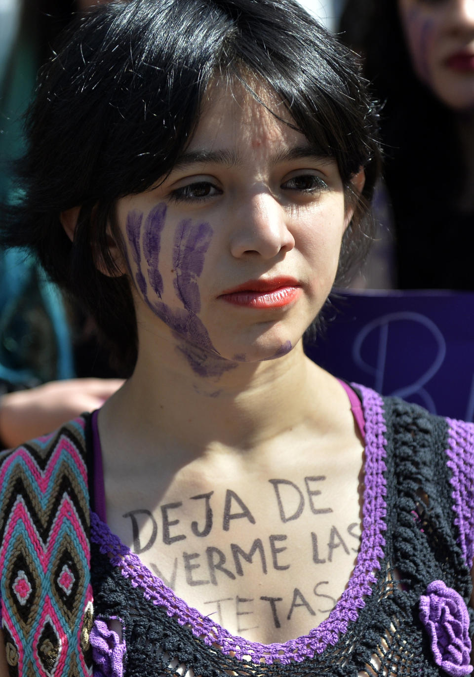 A woman in Mexico City with the sentence "Stop Looking at my Breasts" written on her chest takes part in October 19 protests.&nbsp;