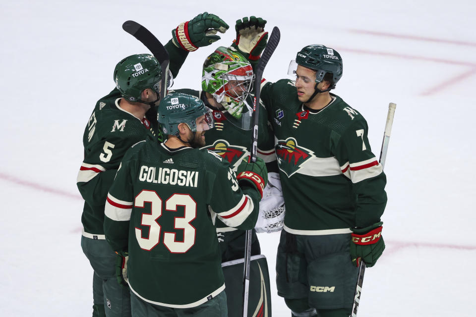 Minnesota Wild goaltender Filip Gustavsson is congratulated by Jake Middleton (5), Alex Goligoski (33) and Brock Faber (7) left after the Wild's win over the Florida Panthers in an NHL hockey game Thursday, Oct. 12, 2023, in St. Paul, Minn. (AP Photo/Matt Krohn)