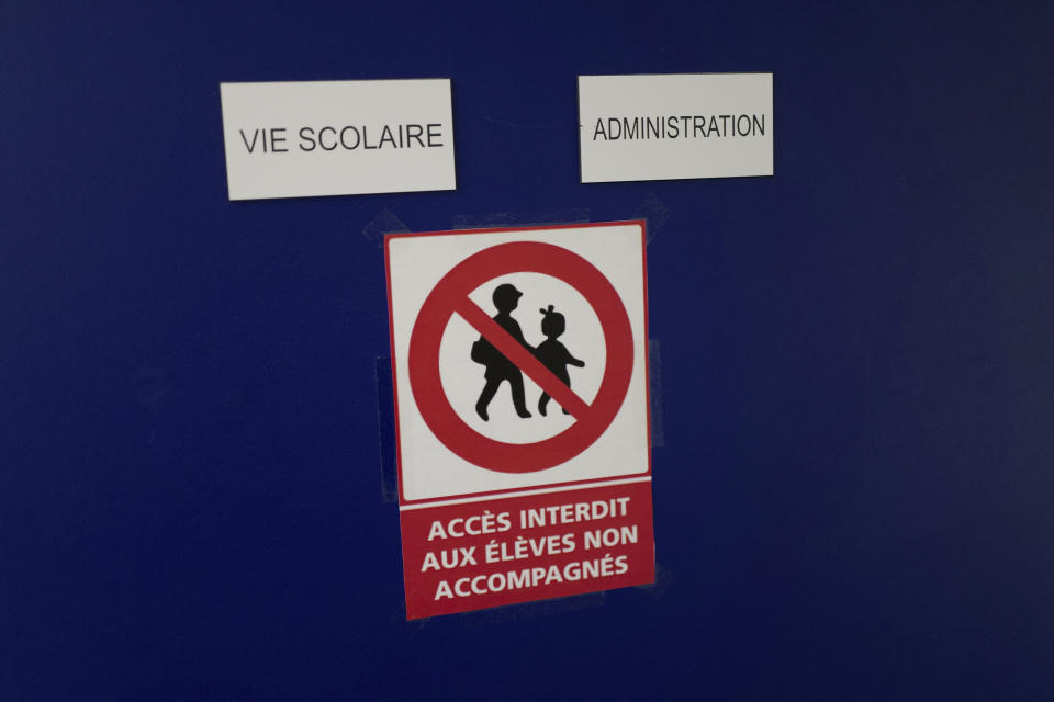 Signs reading "School Life, Administration, access forbidden to unaccompanied students" are pasted on an office door at the MHS, Meo High School private college, in Paris Tuesday, Feb. 9, 2021. More than three dozen police officers descended on the small private school, blocked students inside their classrooms, took photos everywhere, even inside the refrigerator, and grilled the school director in her office. Such operations illustrate French efforts to fight extremism as lawmakers prepare to vote on a bill aimed at snuffing it out. (AP Photo/Francois Mori)
