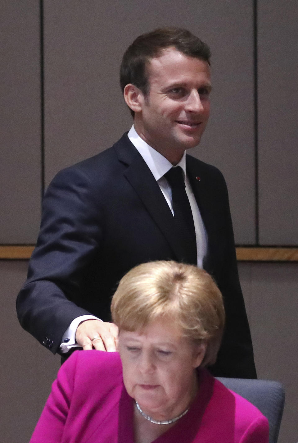 FILE - In this May 28, 2019 file photo, French President Emmanuel Macron, left, puts his hand on the shoulder of German Chancellor Angela Merkel, left, during a dinner meeting at an EU summit in Brussels. French President Emmanuel Macron hosts the G-7 summit this weekend fresh off a meeting with Russia's Vladimir Putin, hoping to maintain his image as a global mediator at a time of deep political and economic insecurity in the world and despite President Donald Trump's open disdain for multilateral talks. (Yves Herman, Pool Photo via AP; File)