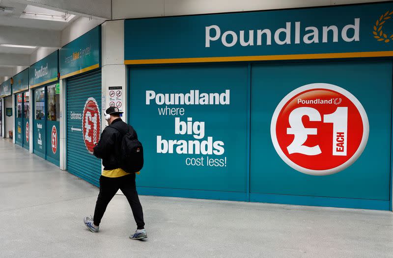 A man walks past a Poundland store in London