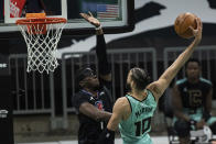 Charlotte Hornets forward Caleb Martin (10) tries to dunk the ball while guarded by Los Angeles Clippers guard Reggie Jackson (1) during the first half of an NBA basketball game in Charlotte, N.C., Thursday, May 13, 2021. (AP Photo/Jacob Kupferman)