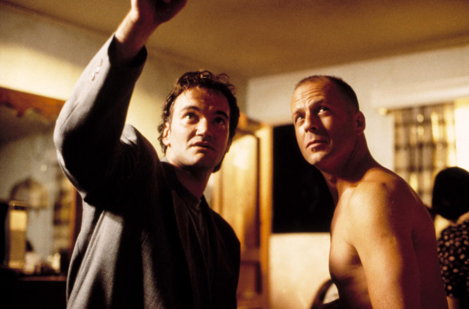 A behind-the-scenes photo of Quentin Tarantino directing Bruce Willis on the set of "Pulp Fiction"