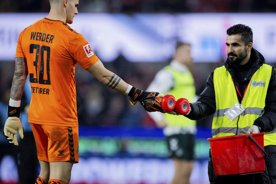 Michael Zetterer, portero del Werder Bremen, entrega un auto a control remoto a un oficial de campo durante el partido de fútbol de la Bundesliga entre FC Colonia y Werder Bremen en el RheinEnergieStadion, en Colonia, Alemania, el viernes 16 de febrero de 2024. (Rolf Vennenbernd/dpa vía AP)