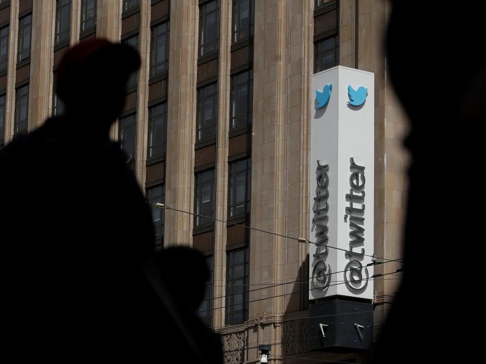 FILE - This July 9, 2019, file photo shows pedestrians walking across the street from the Twitter office building in San Francisco. The Saudi government recruited two Twitter employees to get personal account information of their critics, prosecutors said Wednesday, Nov. 6, 2019. (AP Photo/Jeff Chiu, File)