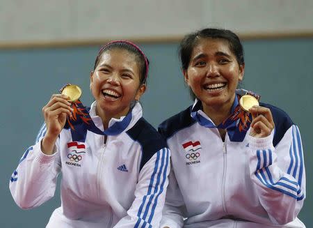 Indonesia's Greysia Polii (L) and Nitya Krishinda Maheswari (R) pose with their gold medals after winning the women's doubles gold medal badminton match against Japan at Gyeyang Gymnasium at the 17th Asian Games in Incheon September 27, 2014. REUTERS/Olivia Harris