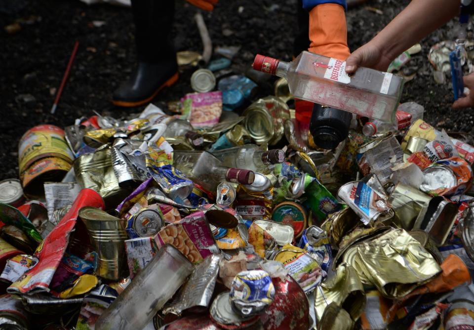 Nepali workers search for recyclable materials froma a pile of waste collected from Mount Everest, in Kathmandu on June 5, 2019. - Aluminium ladders and cans collected from Mount Everest may find a second life as pots and pans, Nepali officials said Wednesday, as some ten tonnes of garbage collected from the world's highest mountain was handed over for recycling. The 14-strong team sent by the government spent about six weeks scouring for litter from base camp to Camp 4 -- nearly 8,000 metres (26,300 feet) up -- scraping together empty cans, bottles, plastic and discarded climbing gear. (Photo by PRAKASH MATHEMA / AFP)        (Photo credit should read PRAKASH MATHEMA/AFP/Getty Images)