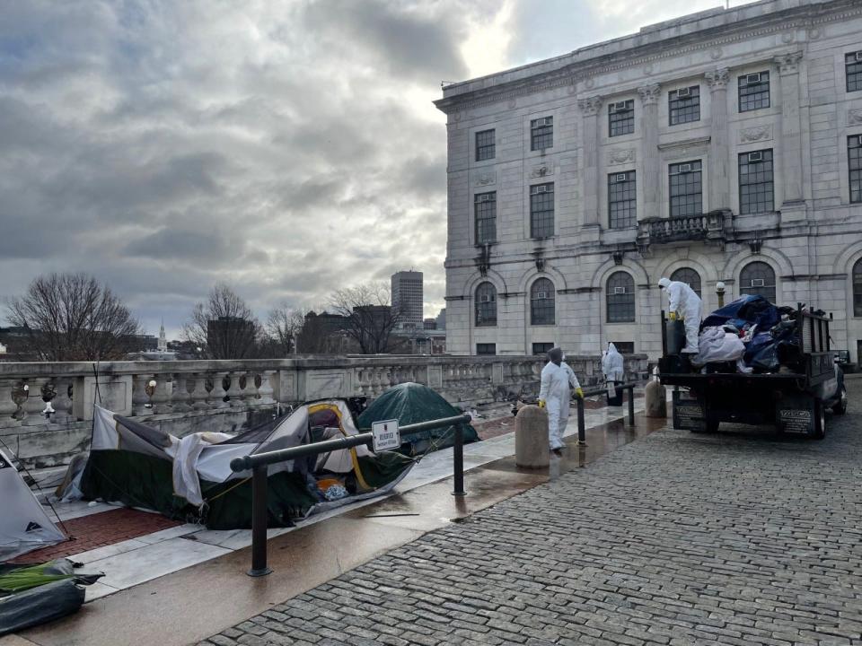 Contractors on Saturday clear tents left by homeless people who had been camped out on the State House terrace.