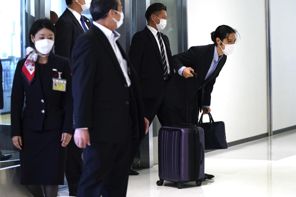 Kei Komuro, right, fiance of Japan's Princess Mako, bows to the media as he arrives at Narita international airport in Narita, near Tokyo, Monday, Sept. 27, 2021 upon returning to Japan from the United States. (AP Photo/Eugene Hoshiko)