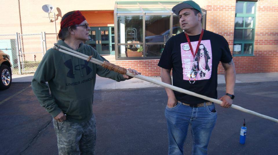 Wayne Valliere and his apprentice, Lawrence Mann, examine a handmade spear they will use to spearfish.