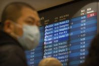 A display board shows a canceled flight arrival from Wuhan at Beijing Capital International Airport in Beijing, Thursday, Jan. 23, 2020. China closed off a city of more than 11 million people Thursday, halting transportation and warning against public gatherings, to try to stop the spread of a deadly new virus that has sickened hundreds and spread to other cities and countries in the Lunar New Year travel rush. (AP Photo/Mark Schiefelbein)