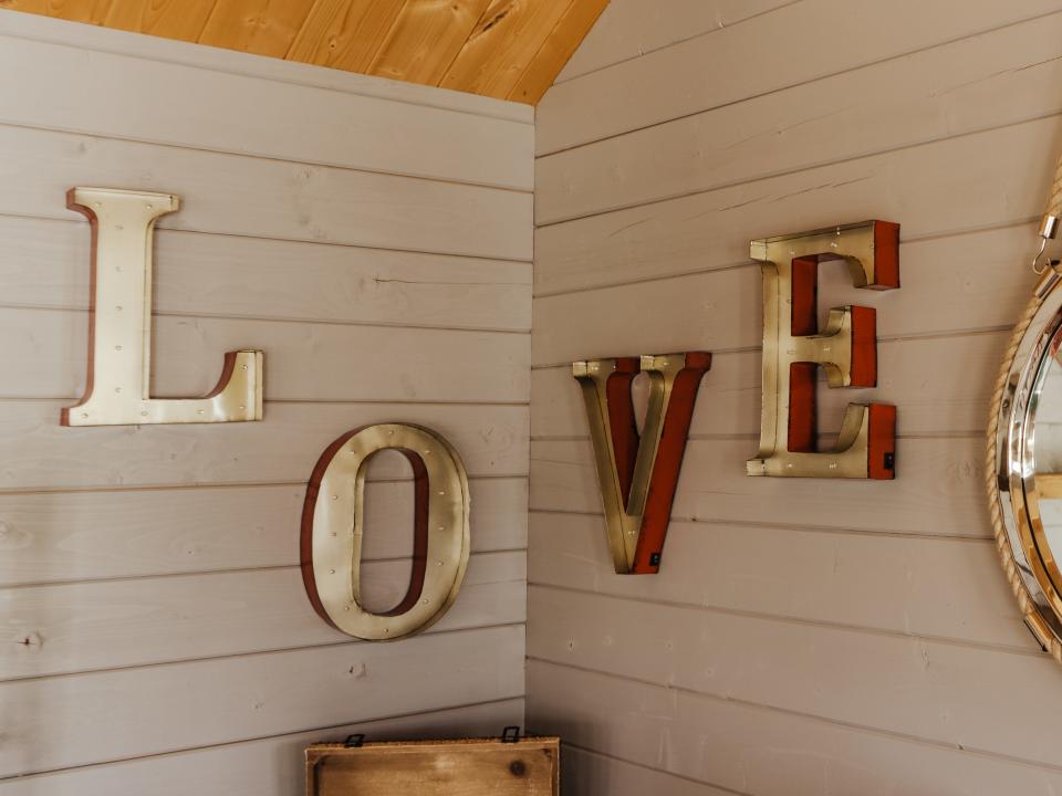 Separated letters spell out "love" on a wall