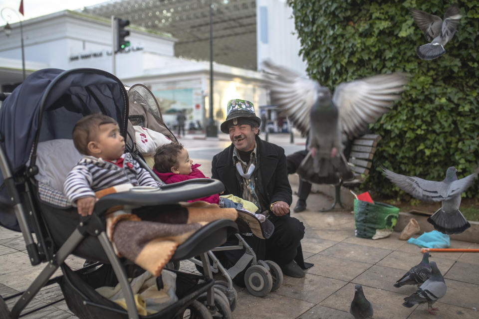 Belhussein Abdelsalam, 58, a Charlie Chaplin impersonator reacts while performing for some children, in an avenue in Rabat, Morocco, Thursday, Dec. 17, 2020. When 58-year-old Moroccan Belhussein Abdelsalam was arrested and lost his job three decades ago, he saw Charlie Chaplin on television and in that moment decided upon a new career: impersonating the British actor and silent movie maker remembered for his Little Tramp character. (AP Photo/Mosa'ab Elshamy)