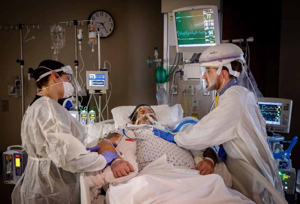 Jennifer Harrison talks with Dr. Tamim Mahayni as he examines her father, Rodney Eurom, in the ICU at Mary Greeley Medical Center.