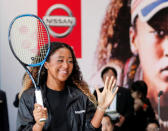 U.S. Open tennis champion Naomi Osaka reacts as she hits a ball to Nissan Motor's Senior Vice President Asako Hoshino after a contract signing ceremony at Nissan's global headquarters in Yokohama, Japan, September 13, 2018. REUTERS/Toru Hanai