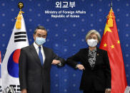 Chinese Foreign Minister Wang Yi, left, and South Korean Foreign Minister Kang Kyung-wha, right, pose together prior their meeting at the foreign ministry in Seoul, South Korea, Thursday, Nov. 26, 2020. Foreign Minister Wang arrived in Seoul on Nov. 25, for a three-day state visit to discuss bilateral high-level exchanges, the situations on the Korean Peninsula and in the region.(Kim Min-hee/Pool Photo via AP)