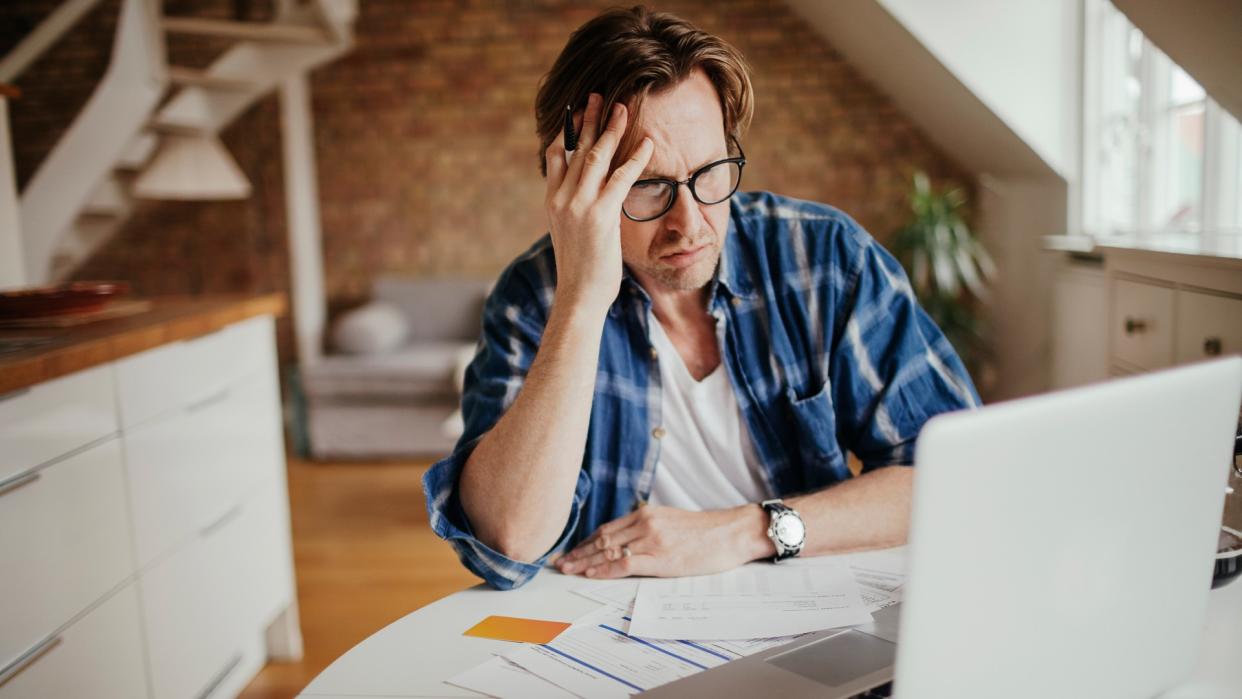 middle aged man looking frustrated with computer