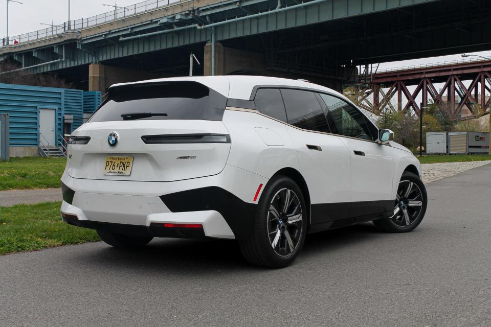 A white 2022 BMW iX xDrive50 SUV seen from a rear three-quarter view.