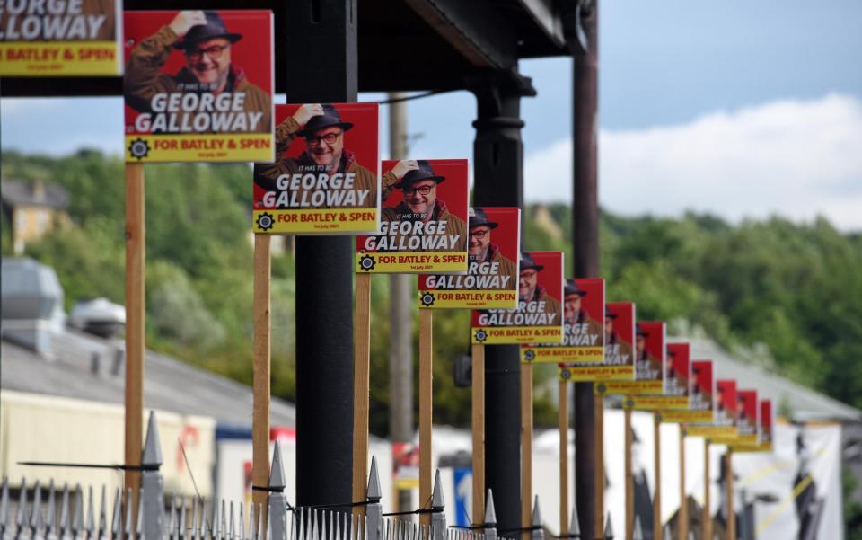 George Galloway Batley and Spen by-election posters arranged in a long row outside campaign headquarters in Bradford Road, Batley. - Asadour Guzelian/Guzelian