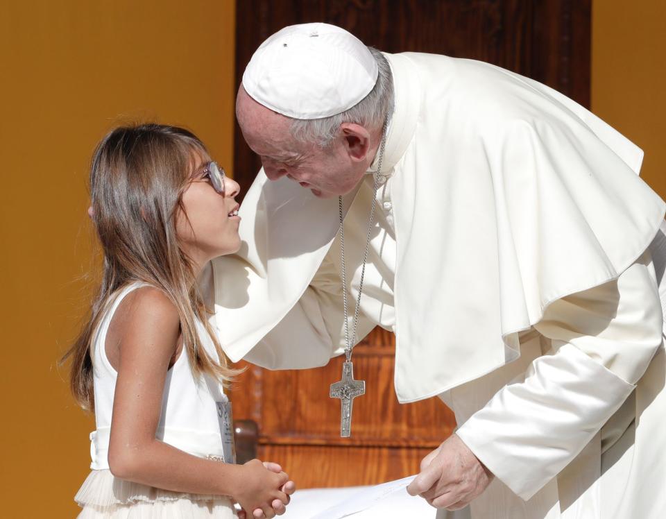 Pope Francis greets a young girl during his visit to