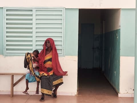 A woman waits with her child to meet the doctor at a Senegal clinic - Credit: Francesco Brembati&nbsp;