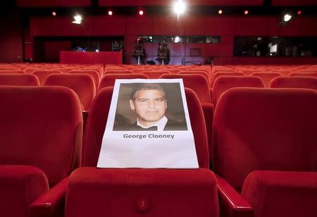 A photograph of George Clooney, cast member in the opening film "Hail, Caesar!" for the upcomming 66th Berlinale International Film Festival, is seen on a seat during a rehearsal for the opening ceremony in Berlin, Germany, February 10, 2016. REUTERS/Fabrizio Bensch