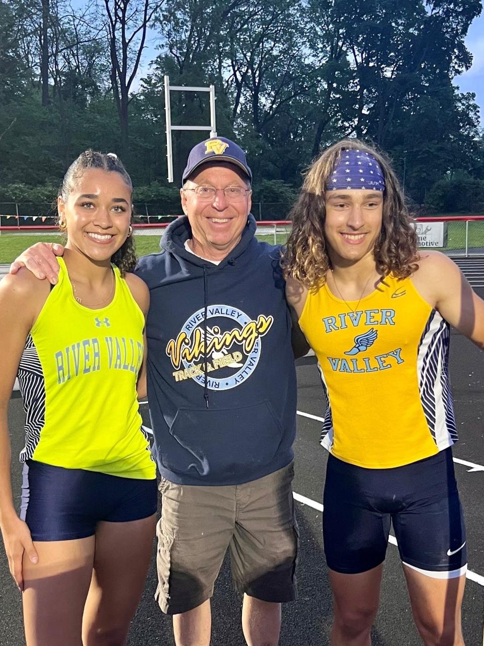 River Valley pole vault coach Kevin Keller, center, poses with Eva Moran, left, and Cooper Miller, two of his athletes who set Mid Ohio Athletic Conference records in the event Tuesday night at Harding Stadium