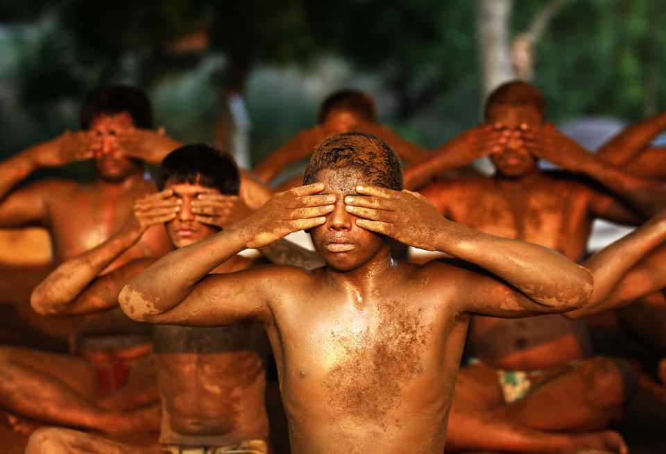 Traditional wrestlers take part in a Yoga workshop after their daily wrestling classes, on June 20, 2015 in New Delhi, India. On June 21, as part of Prime Minister Narendra Modi's International Yoga Day initiative, 45,000 people are expected to set a world record as they practice asanas or positions on the lawns of India Gate. Yoga Guru Baba Ramdev demonstrated a package of Yogic Asanas that keeps people healthy and helps them lead a medicine-free life. In the national capital, 37,000 pink, blue and other coloured mats will make for a pretty backdrop on Rajpath as participants bend and stretch for the 35-minute event.  (Ajay Aggarwal/Hindustan Times via Getty Images)