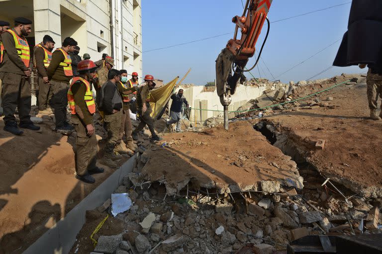 Las autoridades utilizan maquinaria pesada para limpiar los escombros y buscar cadáveres en el lugar del atentado suicida del lunes, en Peshawar, Pakistán, martes 31 de enero de 2023.