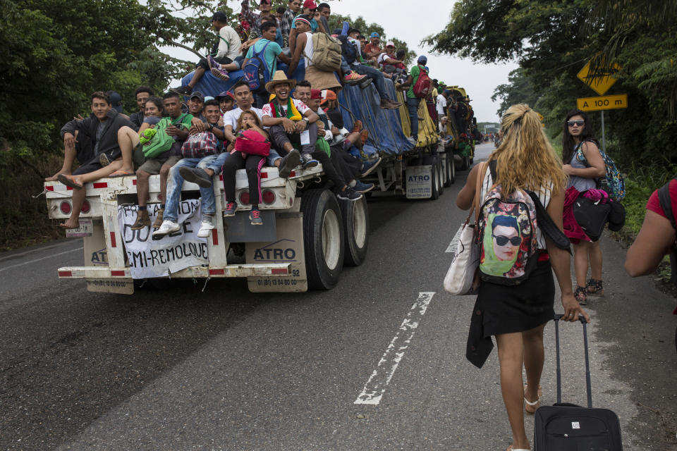 In this Nov. 2, 2018 photo, Central American migrants who hitched a ride on a flatbed truck jeer at members of about 50 LGBTQ migrants who are also part of the caravan hoping to reach the U.S. border, on the road to Donaji, Mexico. For the dozens of transgender women and gay men, the journey has meant putting up with insulting catcalls and even some physical abuse. (AP Photo/Rodrigo Abd)