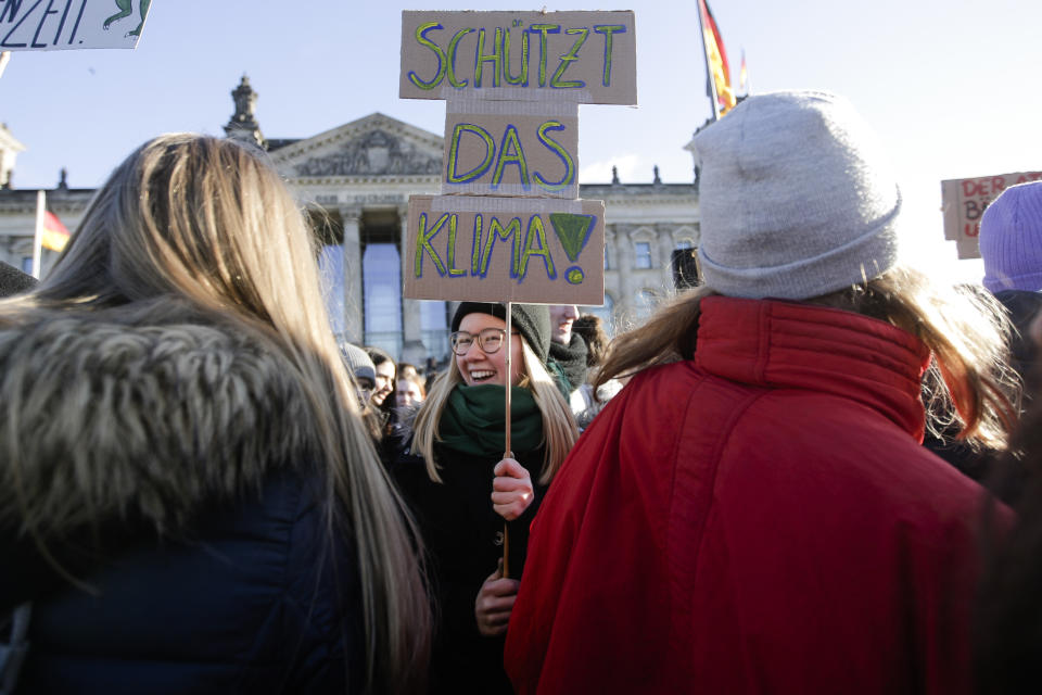 A woman with a poster reading 'Safe the climate' attends the 'Youth For Climate' strike protest in front of the Reichstag building in Berlin, Friday, Jan. 18, 2019. (AP Photo/Markus Schreiber)