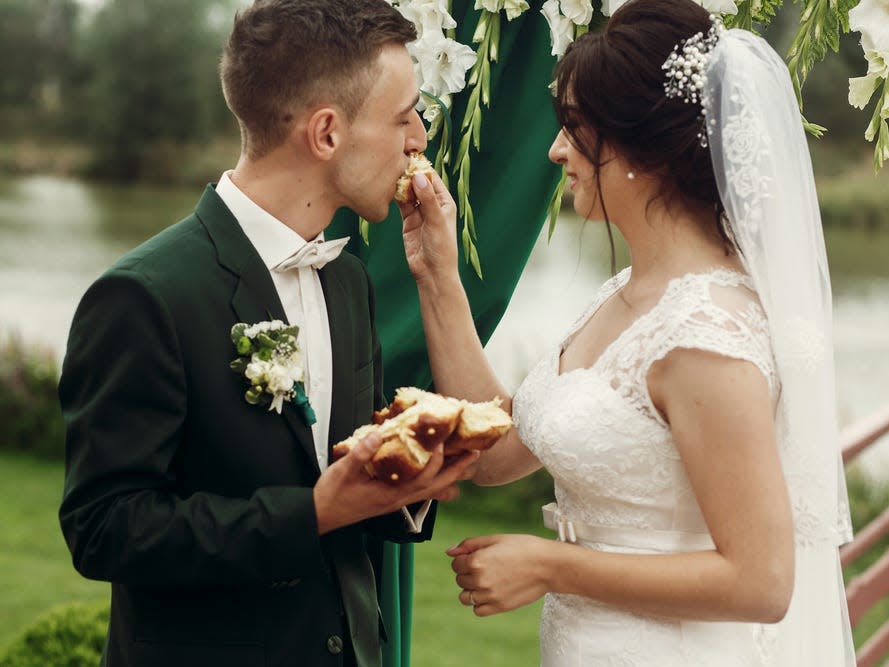 A couple feeds each other cake at their wedding